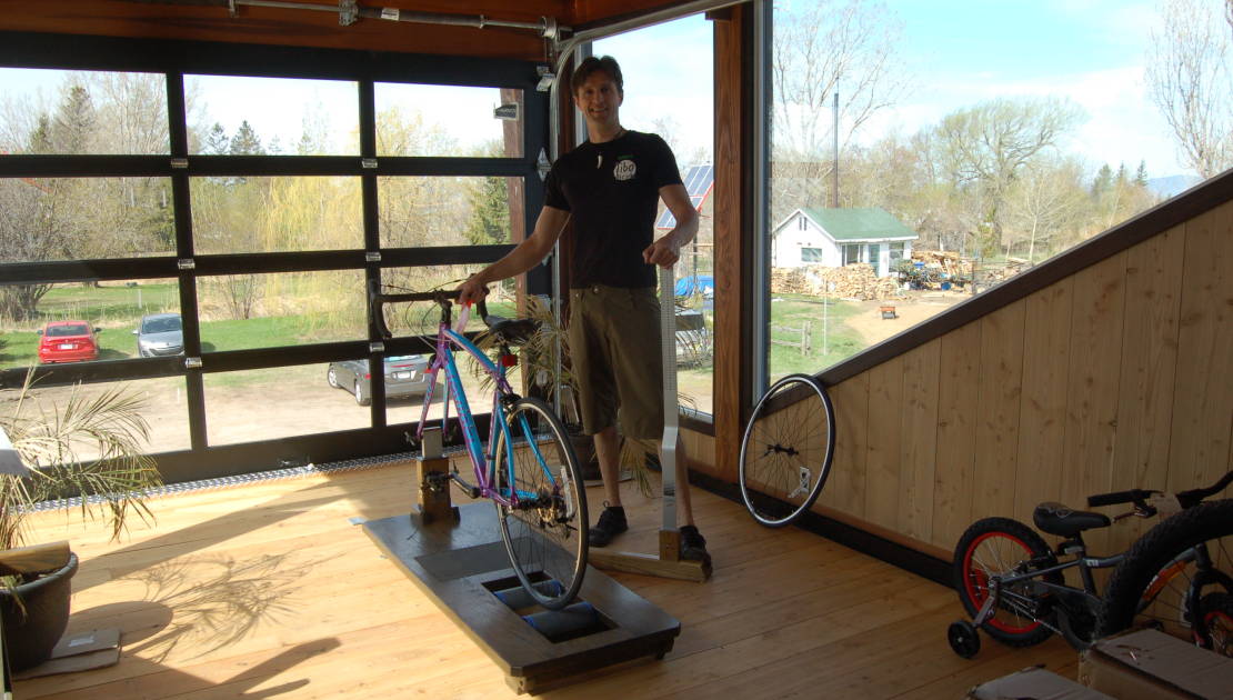 Virus ou pas, Tibo Bicyk a toujours le vent dans les voiles Gilbert Thibault à côté de la machine à positionnement qui permet d’assurer un confort maximal au cycliste et d’éviter les blessures tout en augmentant la performance et le plaisir. La porte de garage en arrière-scène peut s’ouvrir par beau temps pour ajouter au plaisir du cycliste.