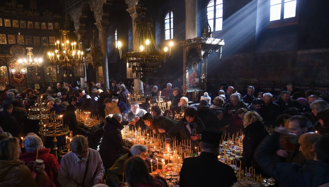 Believers attend a ceremony marking the day of Saint Haralampi, protector of beekeepers, around a cross-shaped platform covered with candles placed in jars of honey, at the Church of the Blessed Virgin in Blagoevgrad, on February 10, 2020. (Photo by NIKOLAY DOYCHINOV / AFP)