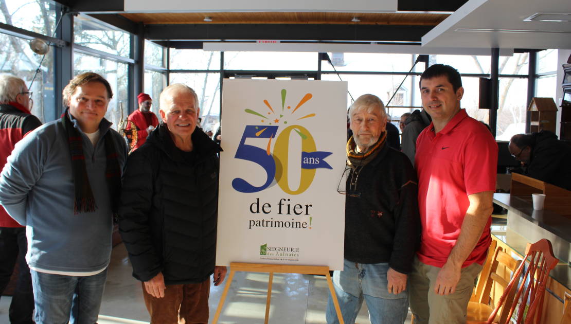 De gauche à droite : André Anglehart, directeur général de la Seigneurie des Aulnaies, André Simard, maire de Saint-Roch-des-Aulnaies, Alain Paradis, membre de les Amis de la Seigneurie, et Éric Dufresne, président de la Corporation touristique de la Seigneurie des Aulnaies, avec le logo pour le 50e anniversaire.