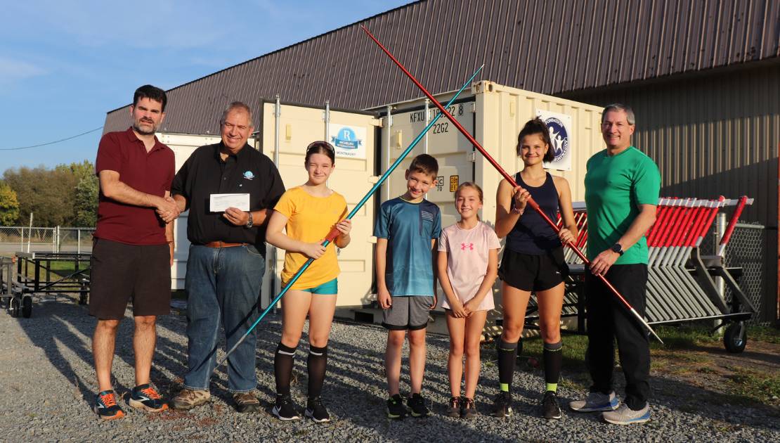 Le président de la Fondation, André Corriveau, remet un chèque à Jonathan Fortin, président du Club. Ils sont accompagnés de jeunes athlètes et de l’entraineur Patrick Bacon.