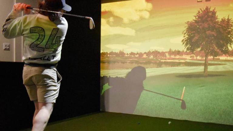 $!Un élève inscrit au golf parascolaire pratique sur le simulateur de Pierre Fréchette, président du Club de golf de Montmagny.